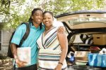 boy posing with his mom as they move him into college - power of attorney for college student concept